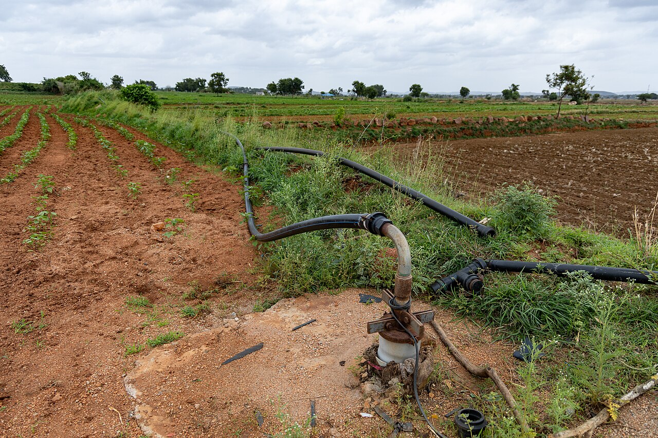 Pump on a drilled well (borehole) with pipe distribution for irrigation on an agricultural plot